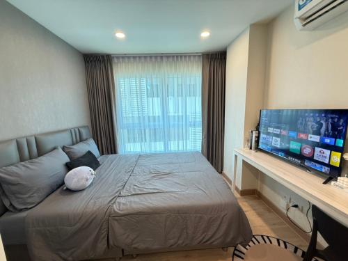 a bedroom with a bed and a flat screen tv at AVALYN Sweet Room - East Ville in Ban Hua Khao Sammuk