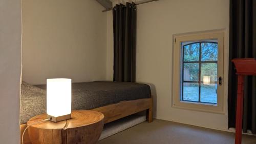 ein Schlafzimmer mit einem Bett und einem Tisch mit einer Lampe in der Unterkunft Ferienhaus mit großer Terasse in Kellenhusen