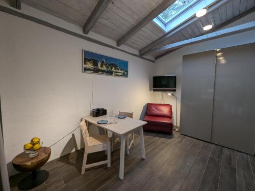 Zimmer mit einem Tisch und einem roten Stuhl in der Unterkunft Ferienhaus mit großer Terasse in Kellenhusen