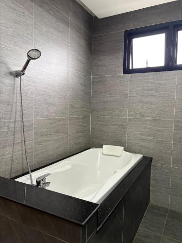 a bath tub in a bathroom with a window at Jazzy Pool Villa Hatyai in Hat Yai