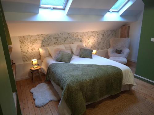 ein Schlafzimmer mit einem großen Bett und einem Stuhl in der Unterkunft Thermo'Spa - Gîte Spa Privatif in Calais