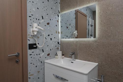 a bathroom with a white sink and a mirror at Comfort Rezidence In Hotel in Tirana