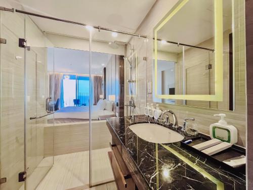 ニャチャンにあるINFINITY OCEAN PALACE PANORAMA Nha Trang Centerの洗面台とシャワー付きのバスルーム