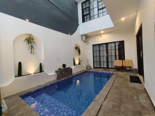 a swimming pool in a house with blue tiles at savilla1 4 kamar dobel bed kolam renang dan biliard in Tlekung