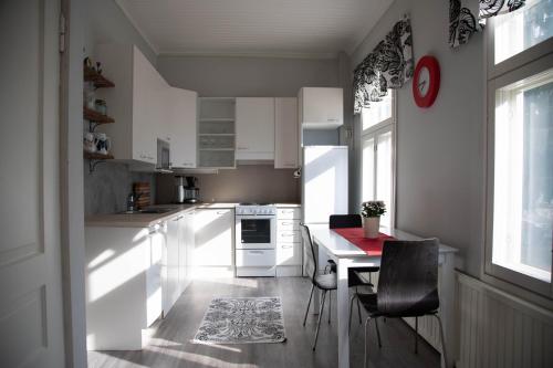 una cucina con mobili bianchi, tavolo e sedie di Willa Wanha Apteekki a Seinäjoki