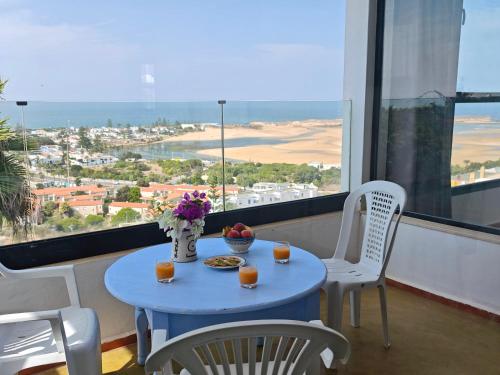 a table with two chairs and a blue table with two drinks at Appartement Coucher de Soleil Vue sur Mer pour les familles in Oualidia