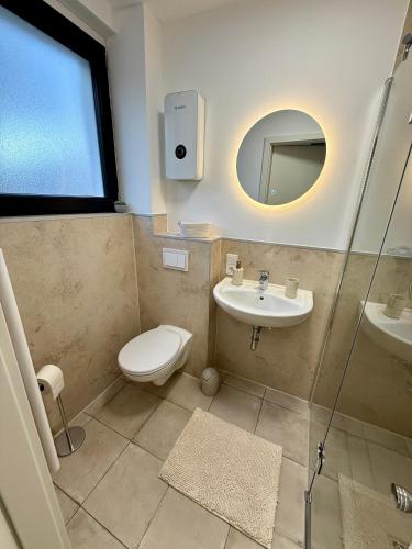 a bathroom with a toilet and a sink and a mirror at Grüne Oase in Stadtnähe in Unna