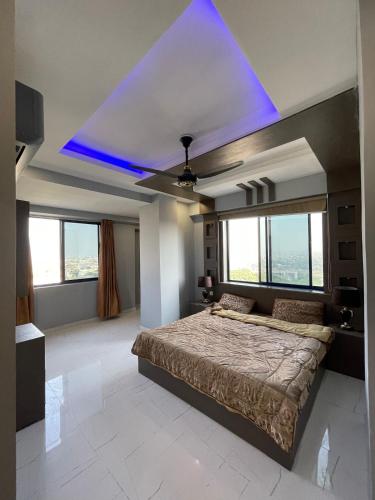 a bedroom with a large bed with a blue ceiling at The Triple-Bedroom Escape in Rawalpindi