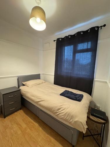 EarlswoodにあるLondon Gatwick Guest Houseのベッドルーム1室(黒いカーテン付きのベッド1台付)