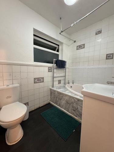 EarlswoodにあるLondon Gatwick Guest Houseのトイレ、洗面台、浴槽を備えたバスルーム