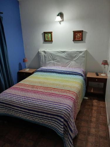 ein Schlafzimmer mit einem Bett mit einer gestreiften Decke in der Unterkunft Lo de Alfonso in San Bernardo