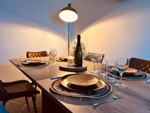 een tafel met een fles wijn en glazen erop bij Au Bord du Logelbach in Colmar