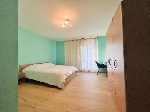 een slaapkamer met een bed, een tafel en een stoel bij Au Bord du Logelbach in Colmar