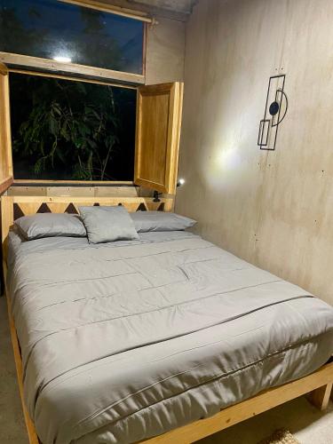 a bed in a room with a window at EB5 Escape Tzununa, Lake Atitlan Room #3 - two minute walk to the Lake in Tzununá