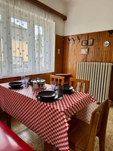 a dining room table with a red and white checkered table cloth at Fehérlak in Tata