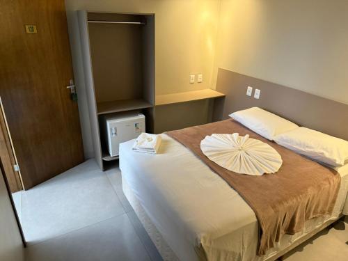 a bedroom with a bed with a umbrella on it at Royal Hotel in Dourados