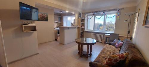 a living room with a couch and a table at Wolfs apartment in Rīga