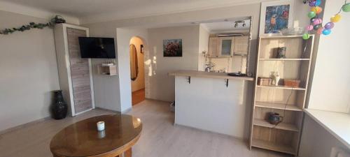 a living room with a table and a kitchen at Wolfs apartment in Rīga