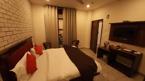 a hotel room with a bed and a television at Hotel Premium in Chandīgarh