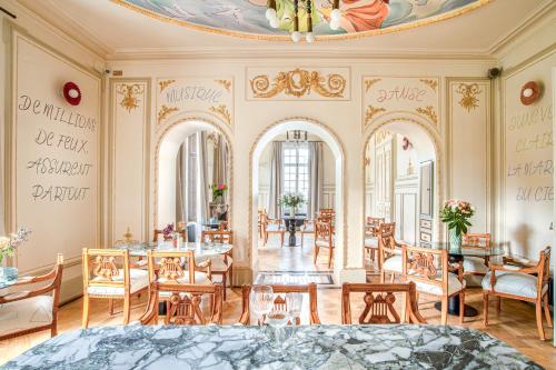 Una habitación con mesas y sillas y un techo. en Verneuil la douce, en Verneuil d'Avre et d'Iton