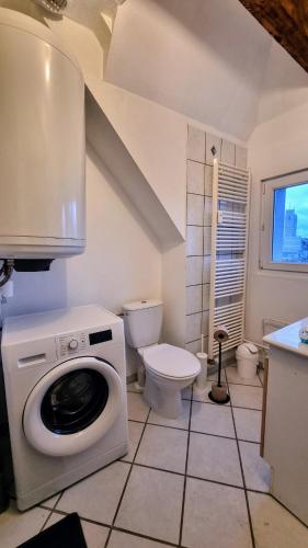 a bathroom with a washing machine and a toilet at Duplex sous mon toit in Altkirch