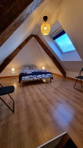 1 dormitorio en el ático con cama y ventana en Duplex sous mon toit, en Altkirch