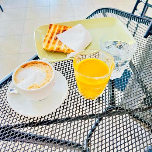 Sonhozinho House Colico في كوليكو: طاولة مع طبق من الطعام وكوب من عصير البرتقال