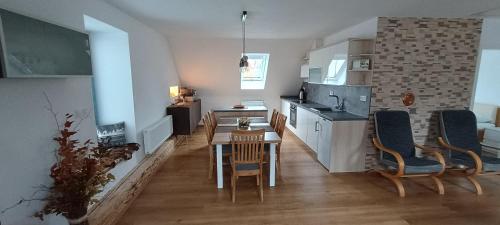 Una cocina y un comedor con mesa y sillas. en Apartmán Jana, en Vysoké Mýto