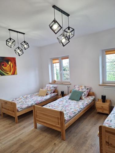a room with two beds and two windows at Agroturystyka Cieślarówka in Lubawka