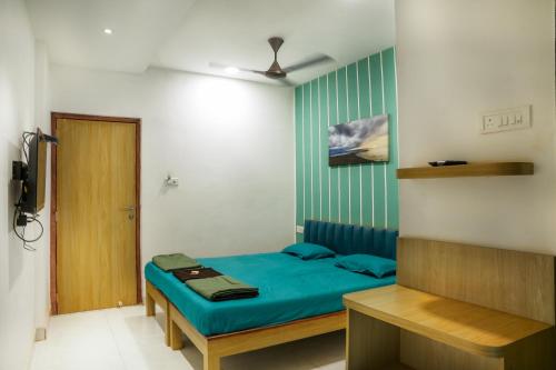 ダポリにあるHotel Royal Usiのベッドルーム1室(青いシーツとドア付)