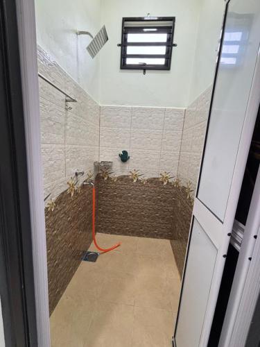 a bathroom with a shower with an orange hose at D Bukit homestay in Ketereh