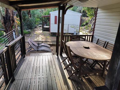 a wooden deck with a table and chairs on it at Mira Monti Location in Belvédère