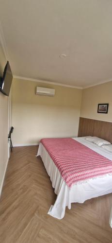 a bedroom with a large bed with a red blanket at Ecopousada Miriti in Belém