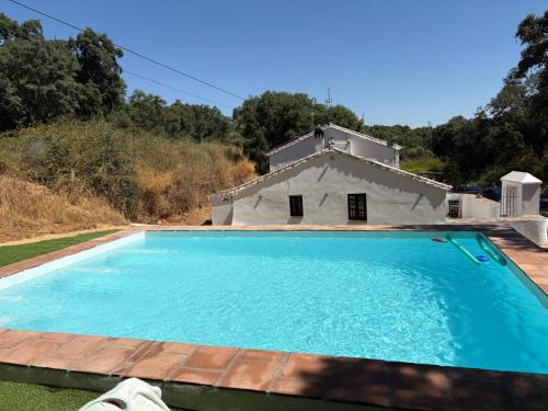 a swimming pool in front of a house at Cortijo Rural El Contador, con chimenea in Constantina