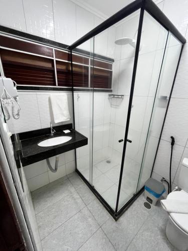 a bathroom with a glass shower and a sink at Pousada La Riviera - Pé na areia e Passeios em Maragogi in Maragogi