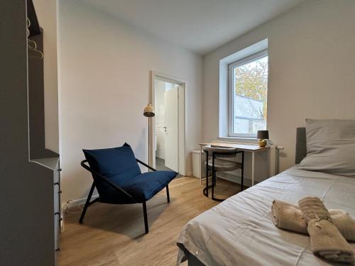 a bedroom with a bed and a chair and a desk at GeBa Bed & Single Rooms in Leipzig