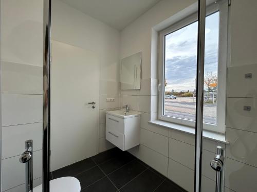 a bathroom with a toilet and a window at GeBa Bed & Single Rooms in Leipzig