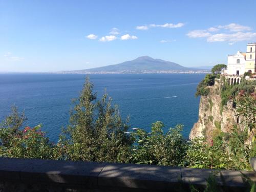 a view of the ocean and a building on a cliff at B&B La Grotta Marina in Vico Equense