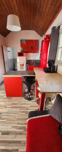 cocina con armarios rojos y suelo de madera en Les coquelicots, en Maimbeville