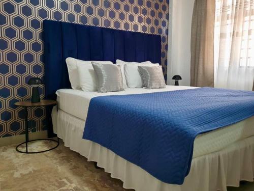 a blue bedroom with a bed with a blue headboard at Sages Place in Gaborone