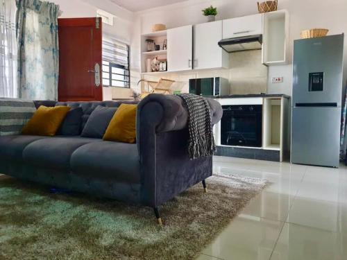 a living room with a blue couch in a kitchen at Sages Place in Gaborone