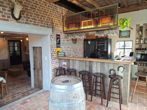 a bar with a bunch of stools and a counter at Vakantiehuis 6 personen-rustig en karaktervol in Geraardsbergen