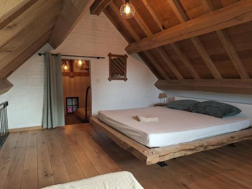 a bedroom with a large bed in a attic at Vakantiehuis 6 personen-rustig en karaktervol in Geraardsbergen