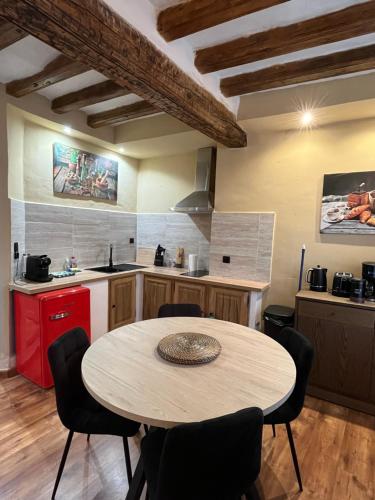 een keuken met een tafel en stoelen in een kamer bij Logement studio avec vue sur le centre Historique in LʼIsle-sur-la-Sorgue