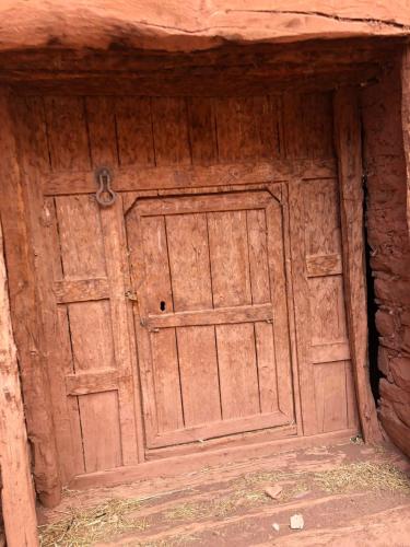 a wooden door in the side of a building at Gite Ifoulou Tassaout in Ifoulo