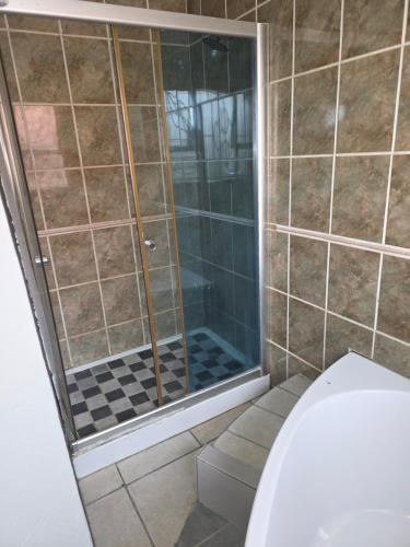 una ducha con puerta de cristal en un baño en The Good Samaritan 2, en Witbank