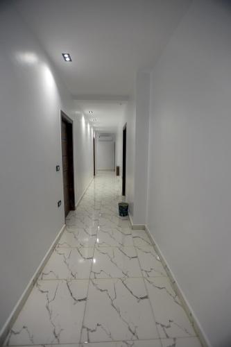 开罗The SACRED ANGLE pyramids view的空的走廊,有白色的墙壁和白色的瓷砖地板