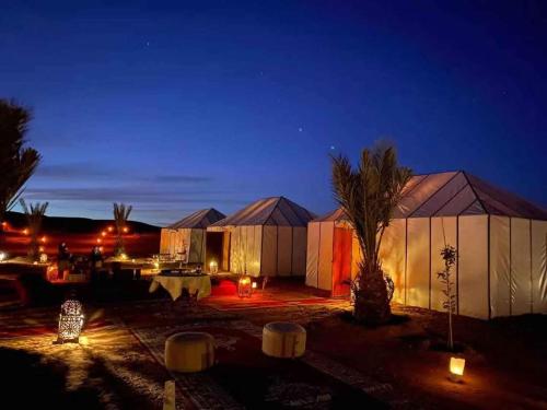 a view of a building at night with lights at enjoy best night in desert merzouga in Merzouga