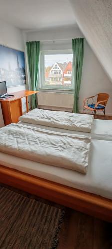 zwei Betten in einem Schlafzimmer mit Fenster in der Unterkunft Ankerplatz Lichtblick in Travemünde