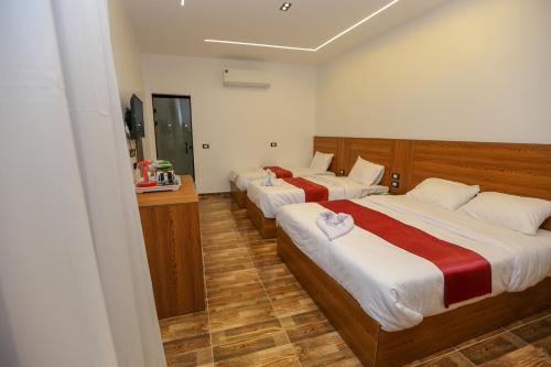 a hotel room with two beds and a television at The Sacred Angle pyramids View in Cairo